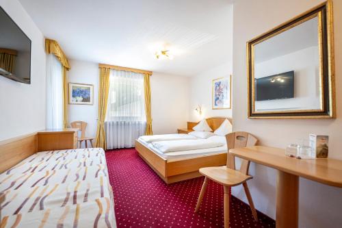 a hotel room with a bed and a mirror at Garni Crepaz in Selva di Val Gardena