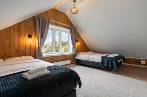 ein Schlafzimmer mit zwei Betten und einem Fenster in der Unterkunft ARCTIC HOMES - Historical Tromsø NEWLY RENOVATED in Tromsø