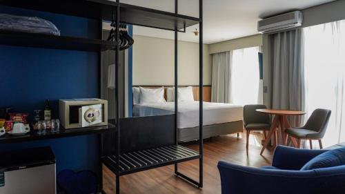 a hotel room with a bed and a tv at Transamerica Executive Paulista in São Paulo