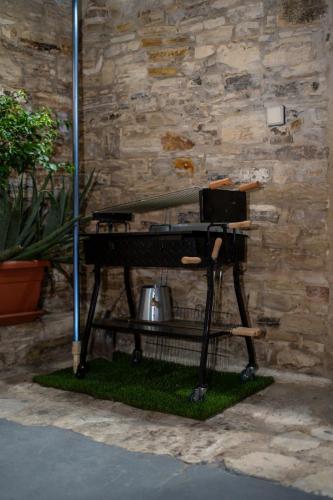 a table with a laptop on it next to a stone wall at RedBlue Door Two Traditional Listed Houses in Pano Lefkara