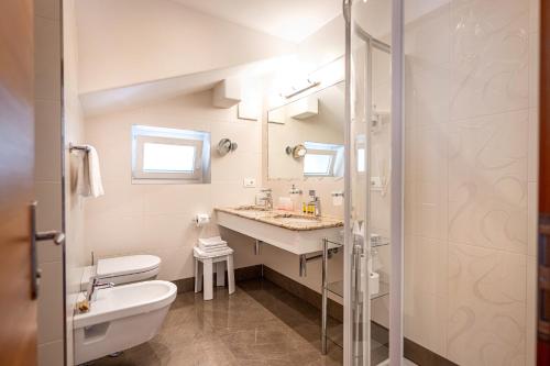 a white bathroom with a sink and a toilet at Garni Crepaz in Selva di Val Gardena