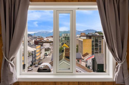 ein offenes Fenster mit Stadtblick in der Unterkunft ARCTIC HOMES - Historical Tromsø NEWLY RENOVATED in Tromsø