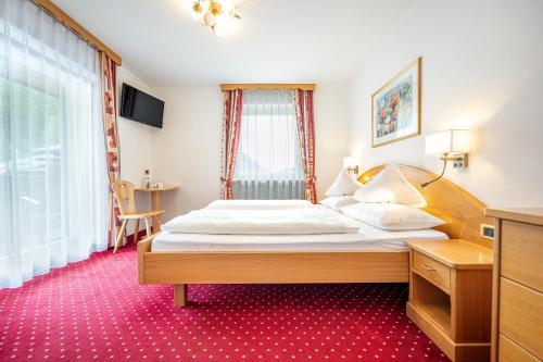 a bedroom with a bed and a window at Garni Crepaz in Selva di Val Gardena