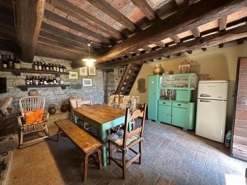 cocina con mesa y nevera verde en Poggi di Belvedere, en Pieve Santo Stefano