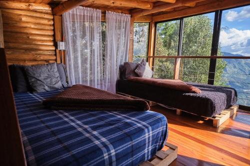 a bedroom with a bed and a couch in front of a window at Skyline Ecoliving Santa Elena in Santa Elena
