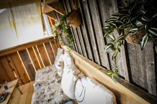 a room with a bed with pillows and plants at Stanzls - Lodge am Lech in Weissenbach am Lech