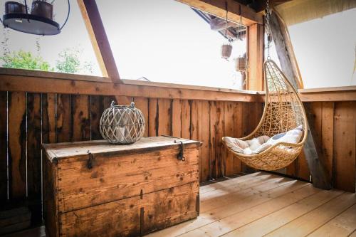 a porch with a hammock and a swing at Stanzls - Lodge am Lech in Weissenbach am Lech