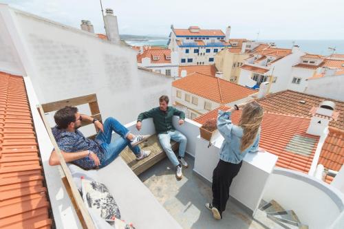 a group of people sitting on the ledge of a roof at WOT Lodge Soul in Ericeira