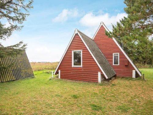 a red house with a gambrel roof at 4 person holiday home in Rømø in Lakolk