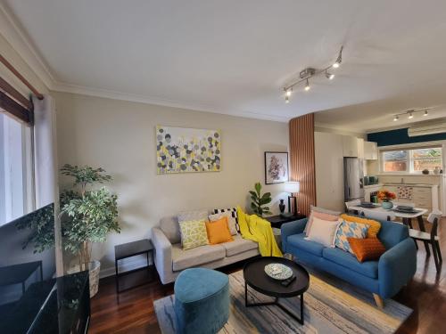 a living room with two couches and a table at Cozy home near Swan River-10 mins to Perth City in Perth
