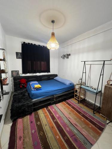 a bedroom with a bed and a large rug at Homey vibes in Agadir