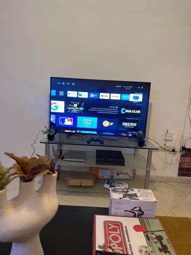 a living room with a large television on a table at Homey vibes in Agadir
