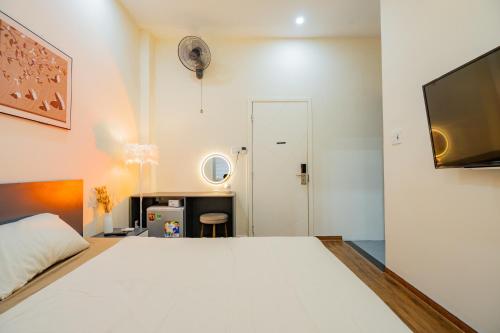 a bedroom with a large white bed and a desk at Aluna Residence Homestay in Da Nang