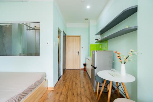 a small kitchen with a table and a refrigerator at Aluna Residence Homestay in Da Nang
