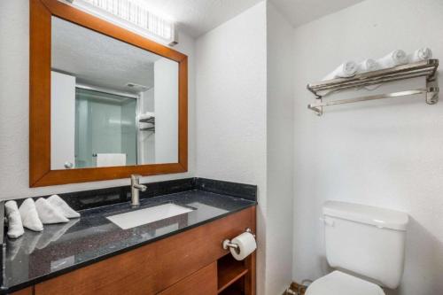 a bathroom with a sink and a mirror at Hotel O Orlando Airport near Florida Mall in Orlando