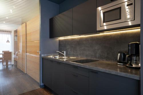 a kitchen with a sink and a microwave at Alagundis Apartment Residence in Lagundo