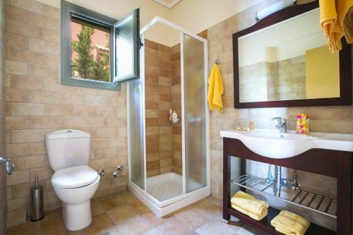 a bathroom with a shower and a toilet and a sink at Villa Leanda by Villa Plus in Lourdhata