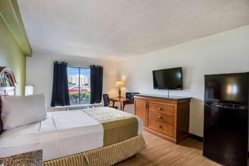 a hotel room with a bed and a flat screen tv at Hotel O Orlando Airport near Florida Mall in Orlando