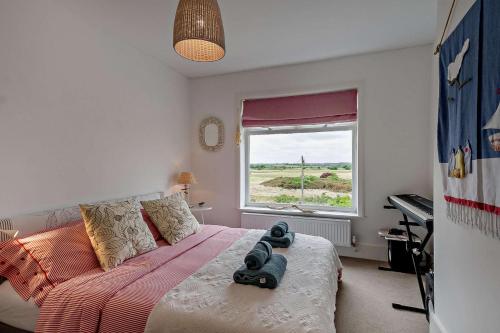 Schlafzimmer mit einem Bett, einem Fenster und einer Tastatur in der Unterkunft The Ferry Cottage in Walton