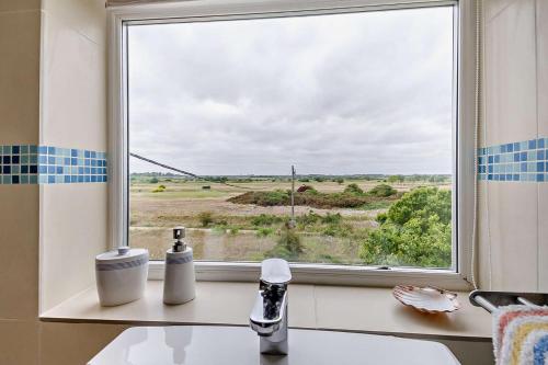 ein Fenster mit Blick auf ein Feld in der Unterkunft The Ferry Cottage in Walton