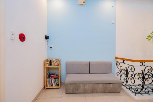a couch in a room with a book shelf at Aluna Residence Homestay in Da Nang