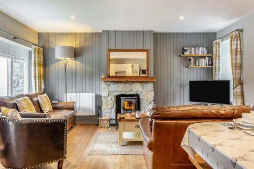 a living room with a couch and a fireplace at 3 Bed in Newtonmore oc-h32416 in Newtonmore