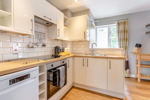 a kitchen with white cabinets and a sink at 3 Bed in Newtonmore oc-h32416 in Newtonmore
