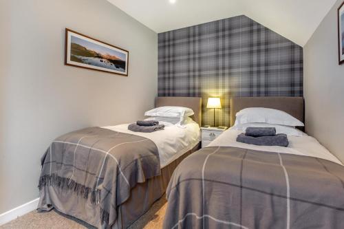 two beds in a small room with aermottermottermott at 3 Bed in Newtonmore oc-h32416 in Newtonmore
