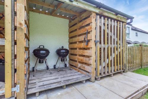 a pergola with two bbqs on a patio at 3 Bed in Newtonmore oc-h32416 in Newtonmore