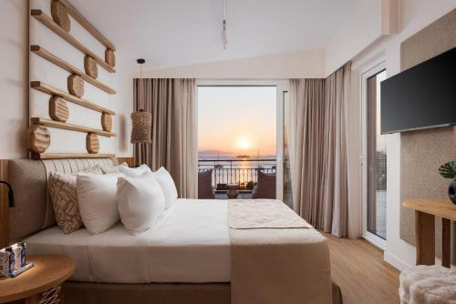 a hotel room with a bed and a view of the ocean at Aegina Dream Suites in Aegina Town