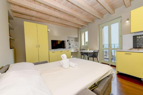 a bedroom with a large bed and a kitchen at Magic apartment with view on Garda lake in the center of Desenzano in Desenzano del Garda