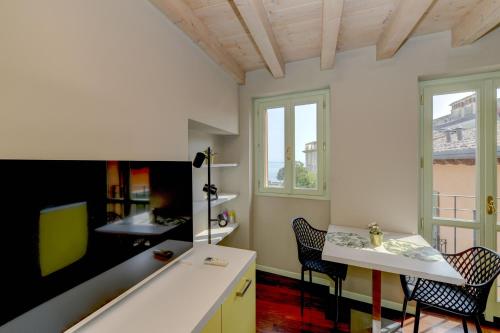 a room with a table and chairs and a window at Magic apartment with view on Garda lake in the center of Desenzano in Desenzano del Garda