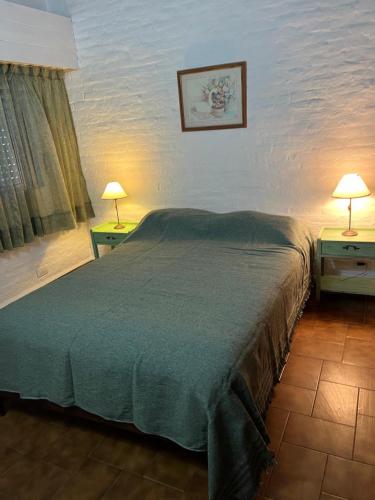 a bedroom with a large bed and two tables with lamps at Apartamento Calamar II in Valeria del Mar