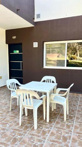 a table and two chairs and a table and chairs at Tata Inti Complejo Serrano in Merlo