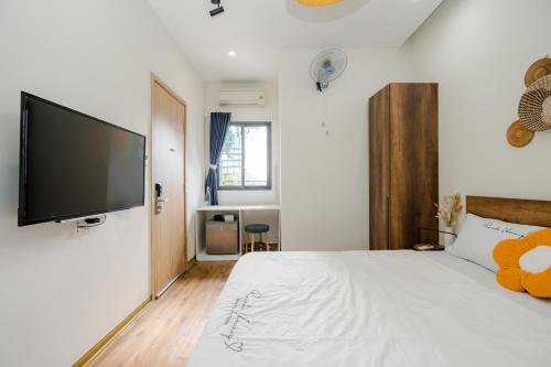 a bedroom with a bed with a flat screen tv on the wall at Aluna Residence Homestay in Da Nang