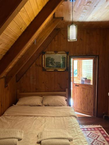 a bedroom with a bed in a wooden house at Hostel & Camping Rilindja in Valbonë