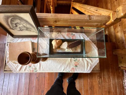 a person is looking down at a glass table with a tray of food at Hostel & Camping Rilindja in Valbonë