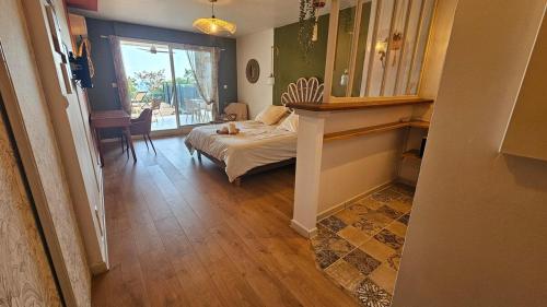 una camera da letto con un letto, un tavolo e una finestra di Summer breeze a Saint-Paul