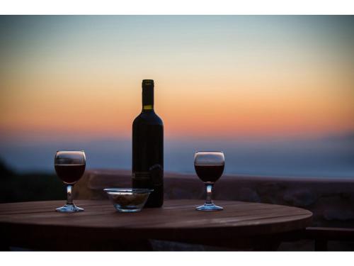 a bottle of wine and two glasses on a table at Pandora in Pirgos Dhirou