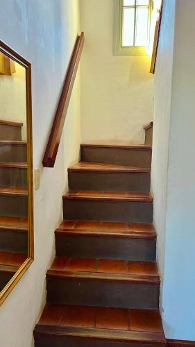 a stairway with wooden steps and a window at Tata Inti Complejo Serrano in Merlo