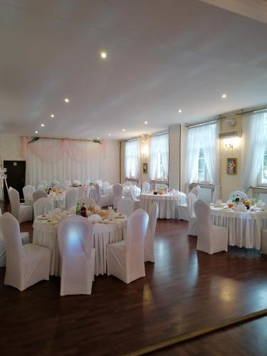 a banquet hall with white tables and white chairs at Hotel i Restauracja Chopin in Żary