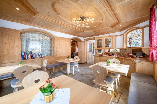 a dining room with tables and chairs and a ceiling at Garni Crepaz in Selva di Val Gardena