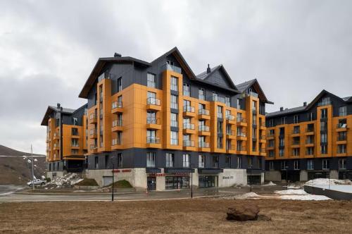a large building with an orange and black at Kala Collection-Timber in Gudauri