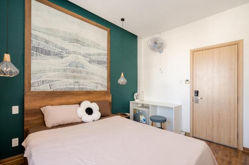a bedroom with a bed with a teddy bear on it at Aluna Residence Homestay in Da Nang