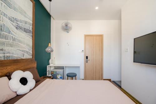 a bedroom with a bed and a flat screen tv at Aluna Residence Homestay in Da Nang