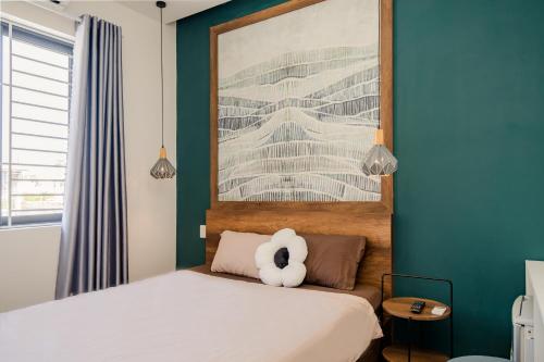 a teddy bear sitting on a bed in a bedroom at Aluna Residence Homestay in Da Nang
