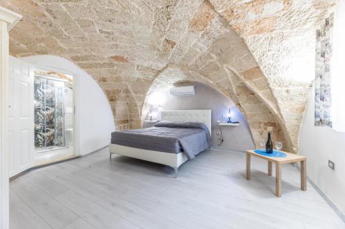 un dormitorio con una cama y una mesa en Casa Charme, en Racale