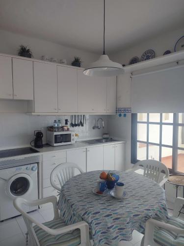 a white kitchen with a table and chairs and a table and a table at Vista Mar Sardina in Gáldar