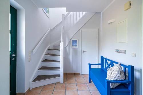 scala bianca in una stanza con sedia blu di SHD19 - FeWo "Gelassenheit" a Neuhaus