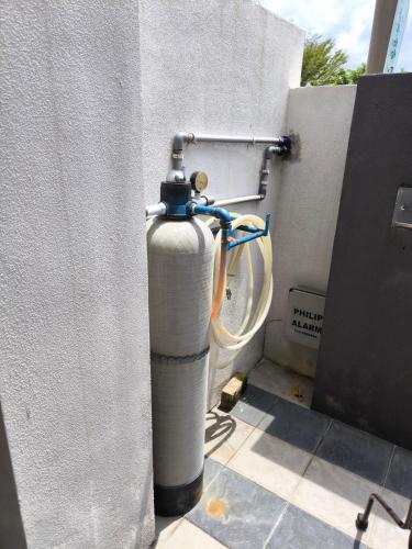 a fire hydrant hooked up to a wall with a bike at De' Jamboree Homestay in Batu Gajah